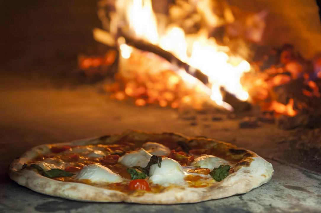 Pizza con la cottura in forno a legna