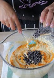 gocce di cioccolato aggiunte alla ciotola con l'impasto