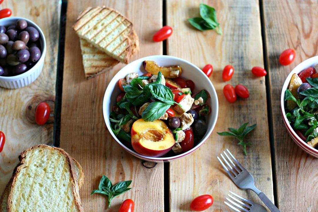 Insalata di pesche, pomodorini, olive nere e feta