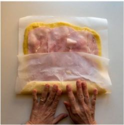 mani che arrotolano la sfoglia di patate farcita
