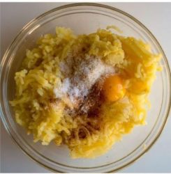 patate in una ciotola con spezie, sale e formaggio
