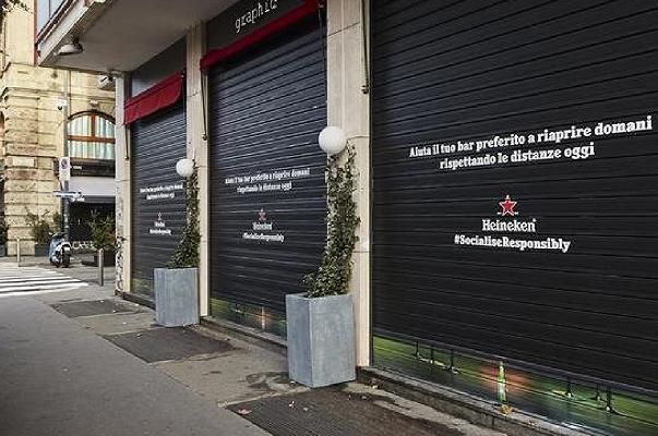 Heineken colora le saracinesche dei bar di Milano per promuovere il distanziamento