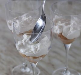 cucchiaio che mette la crema di robiola alla vaniglia sui savoiardi