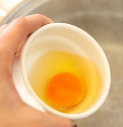 uovo crudo in una ciotola, pronto per essere versato in acqua