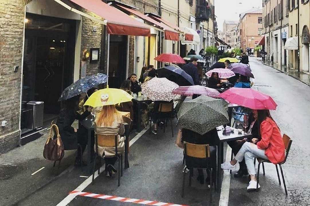Ferrara, cena al ristorante con giacca e ombrello