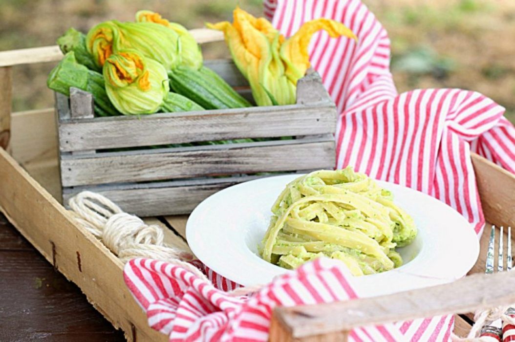 piatto di linguine al pesto in una cassetta di legno