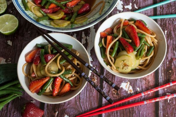 spaghetti con fragole e fagiolini in ciotole e bacchette