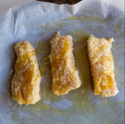 bastoncini di pesce sulla carta da forno oleata