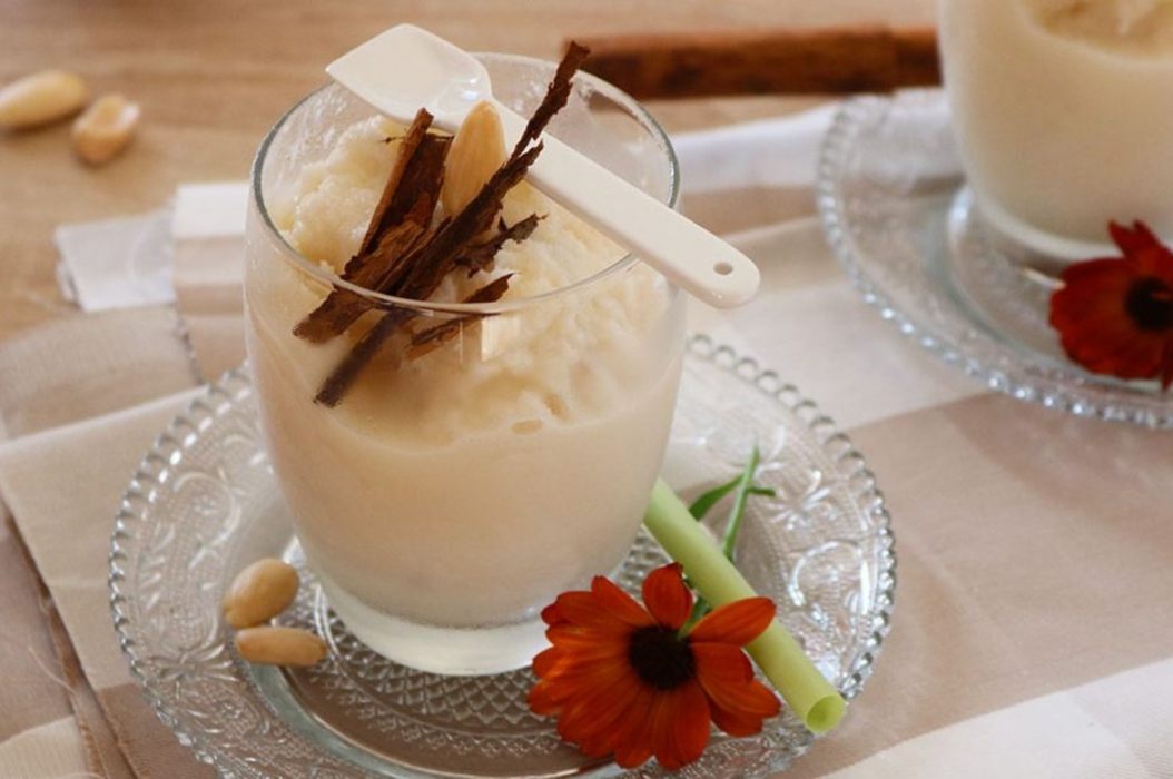 bicchiere con granita di mandorla pezzetti di cannella e un fiore a decorare