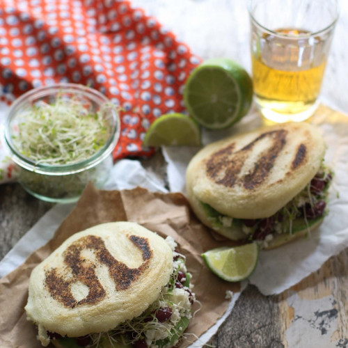 due arepas farcite con germogli e formaggioe una fetta di lime