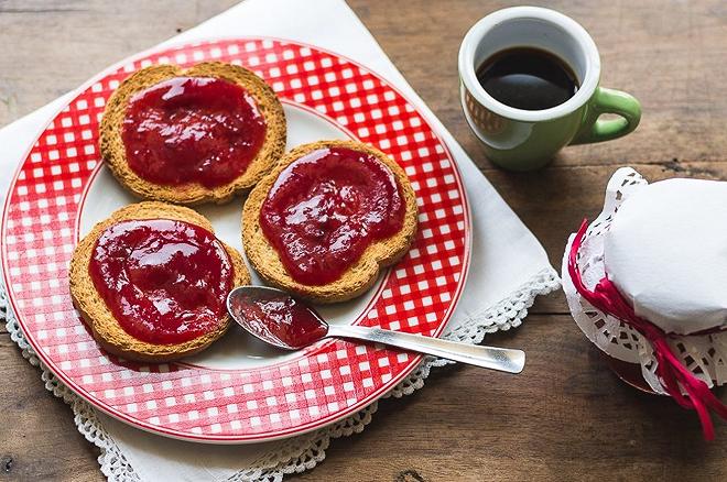 piatto con tre fette biscottate spalmate di marmellata di prugne