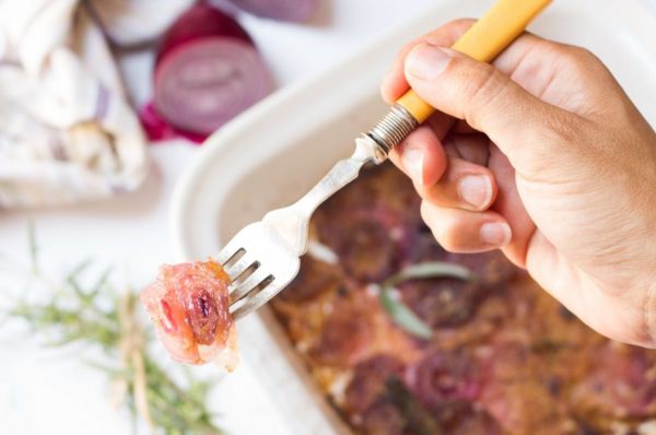 stampo di cipolle gratinate e una forchettata in primo piano