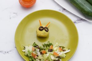 viso del bruco decorato con olive e carote