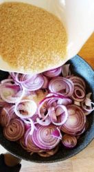 zucchero di canna aggiunto alla padella con le cipolle in padella