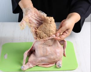 mani che riempiono un pollo