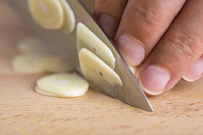 Sbucciate e affettate l'aglio e strofinate il piatto da portata