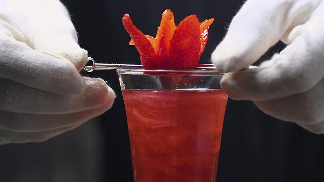 aggiunta di una fragola al bicchiere del rossini cocktail