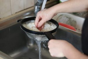 riso lavato sotto l'acqua corrente