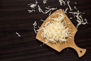 formaggio grattugiato a scaglie su tagliere