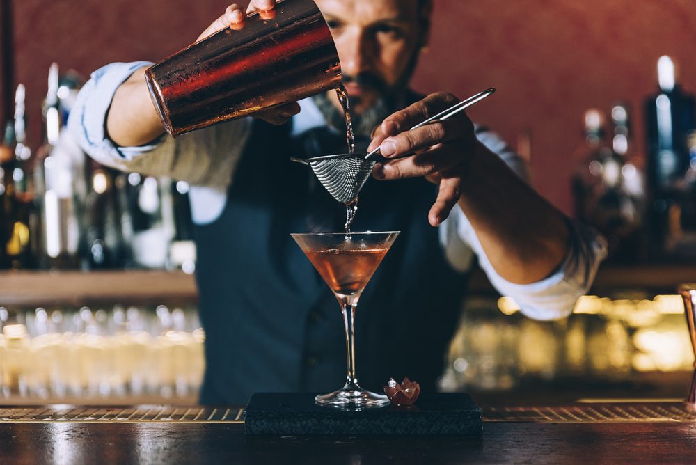 barista filtra cocktail con colino