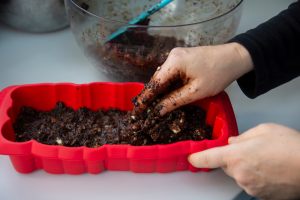 torta al cioccolato messa nella teglia con le mani