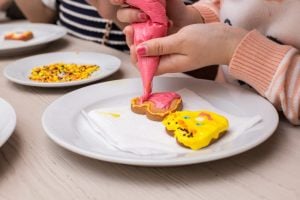 mani di bimbo che decorano i biscotti