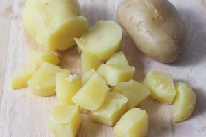 patate tagliate a cubetti su un tagliere