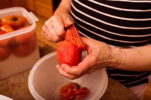 pomodori che vengono pelati a mano