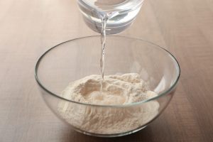 acqua versata sulla farina in una ciotola