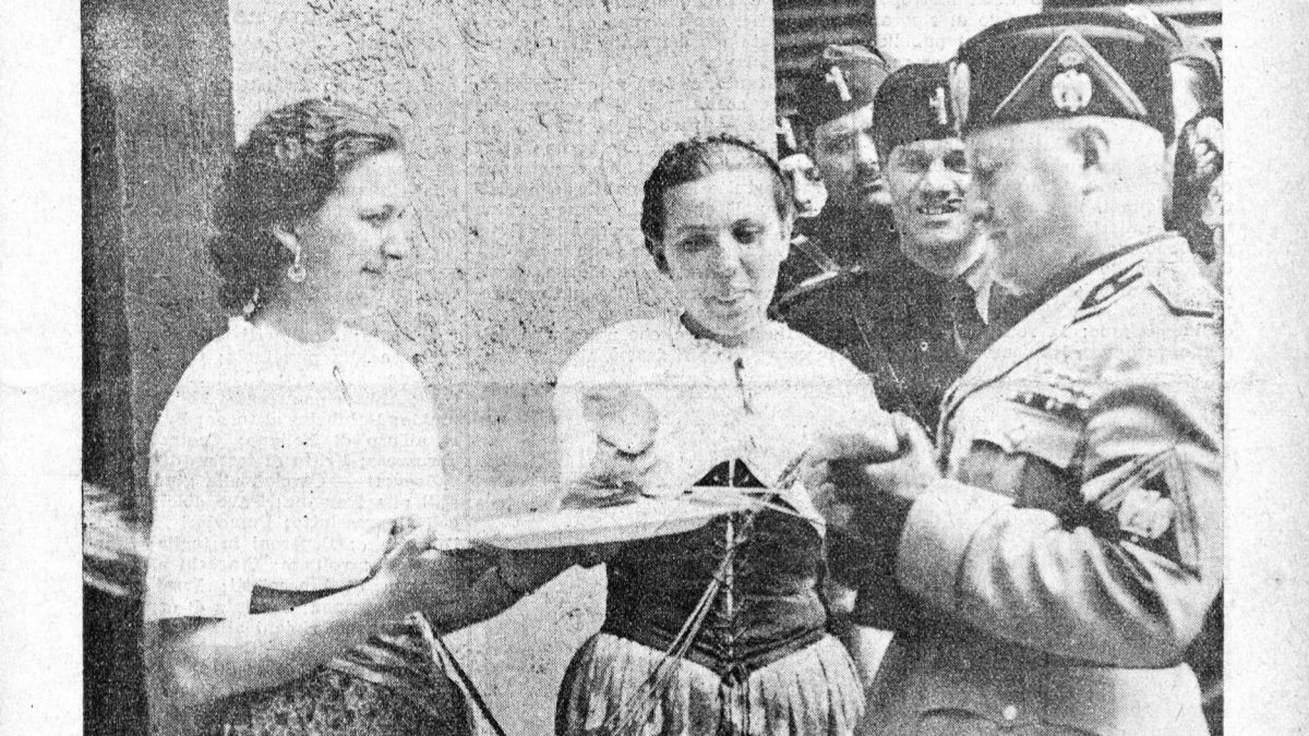 Alla Mostra Nazionale del Dopolavoro inaugurata dal Duce il 24 maggio. Il Duce assaggia il pane che Gli viene offerto dalle Massaie rurali romagnole (La cucina italiana, giugno 1938)