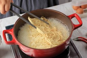 noodles-versati-nella-pentola-di-zuppa-in-cottura