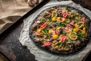 pizza nera con calamari e gamberi appena cotta