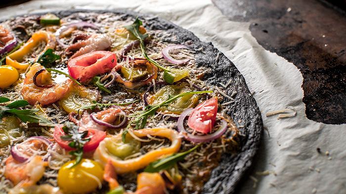 Pizza nera con calamari e gamberi, una ricetta sorprendente