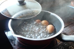 tre uova a bollire in pentola
