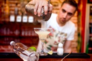 barman che versa il margarita cocktail nel bicchere