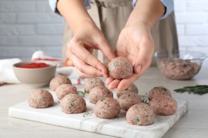 mani che formano le polpette di carne senza uova