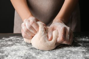 mani che impastano il pane