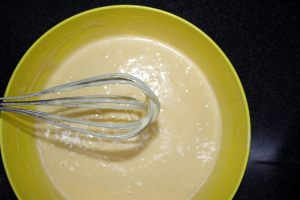 uova sbattute in una ciotola con zucchero e olio