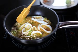 padella con riso e seppie in cottura