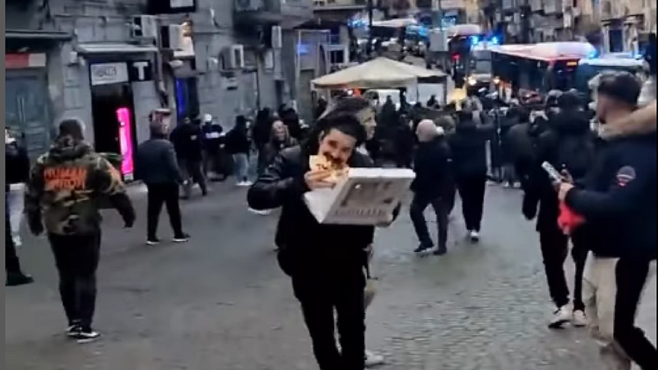 Napoli: continua a mangiare la pizza mentre scappa dagli scontri fra tifoserie, il video