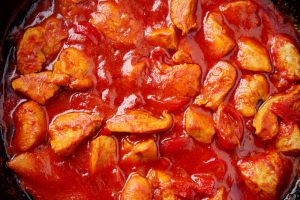 pollo in cottura nella salsa di pomodoro