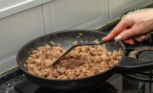 salsiccia macinato e cipolla a cuocere in padella