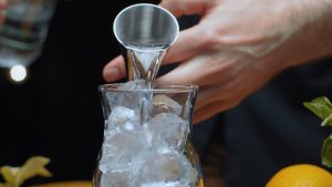 vodka versata in un bicchiere pieno di ghiaccio