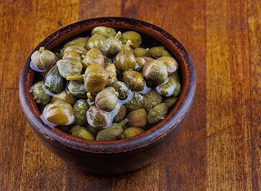 Mettete a bagno i capperi e sbucciate l'aglio