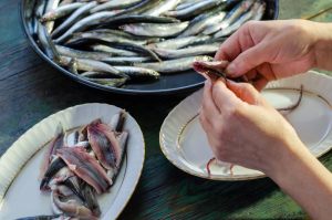 mani che puliscono le sardine