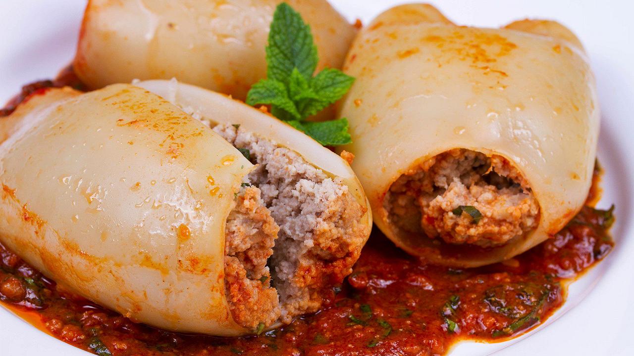 Calamari ripieni al sugo, la ricetta per carni morbide e un ripieno saporito
