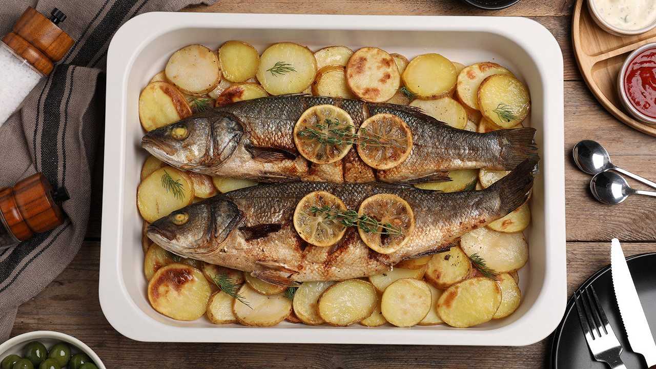 Branzino al forno con patate, una ricetta semplice e d’effetto