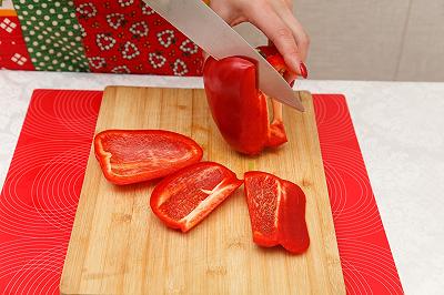 Lavate e affettate peperoni, pomodori e cipolla